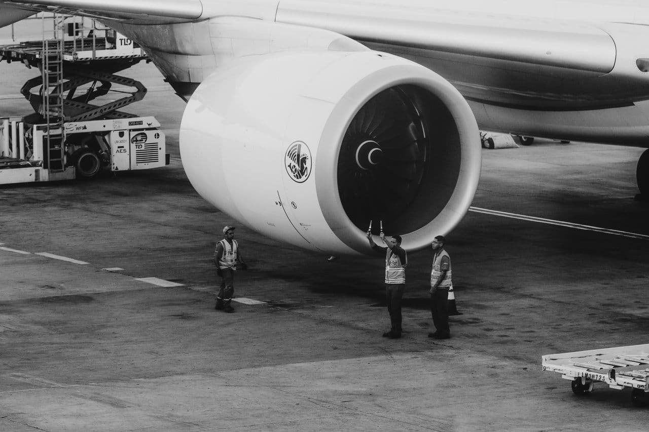 Operadores inspecionando a turbina de um avião